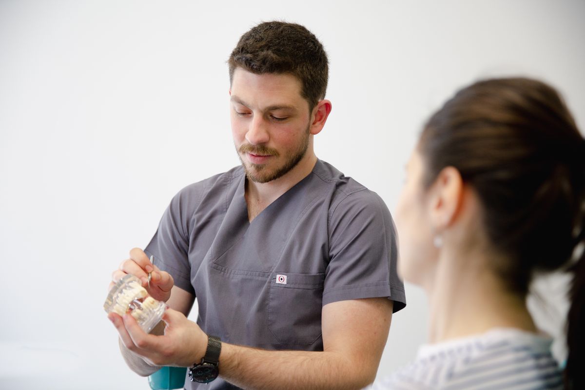 Dentist discussing a dental model with a patient.