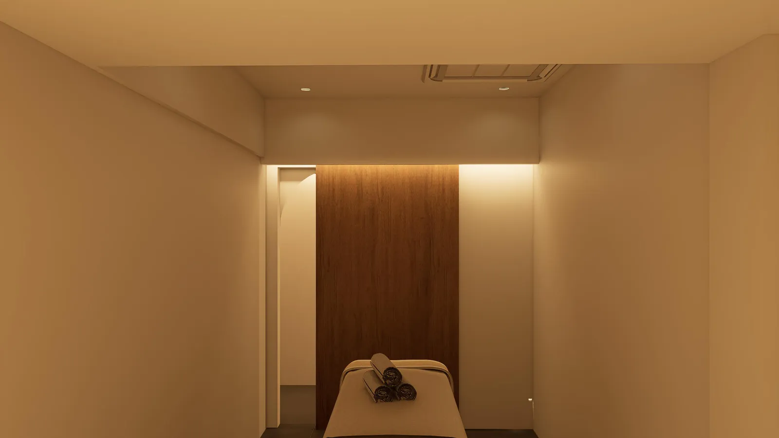 Narrow treatment space showing bed placement and warm low-glare lighting.
