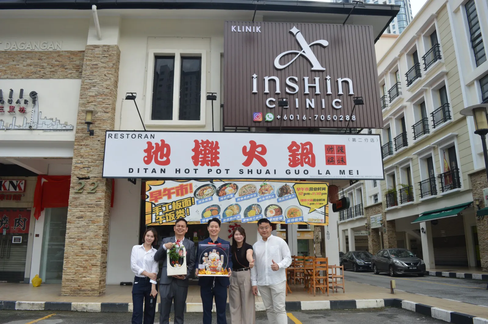 The Inshin Clinic team gathered below the clinic's exterior sign after the opening.